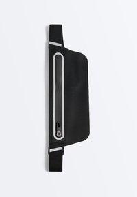 Pochette de taille noire et fine avec fermeture éclair verticale étanche et sangle élastique réglable avec des accents réfléchissants.