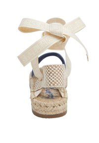 Kootud beež espadrille sandaal tekstureeritud tallaga, sinise aktsendi ja kreemjate rihmadega, mis sisaldavad reljeefset brändimist ja vibu detaili.