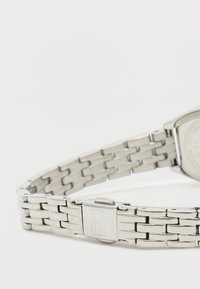 Stainless steel watch with a linked bracelet design. Features a metal clasp and a square case. Smooth, reflective surface with fine detailing.