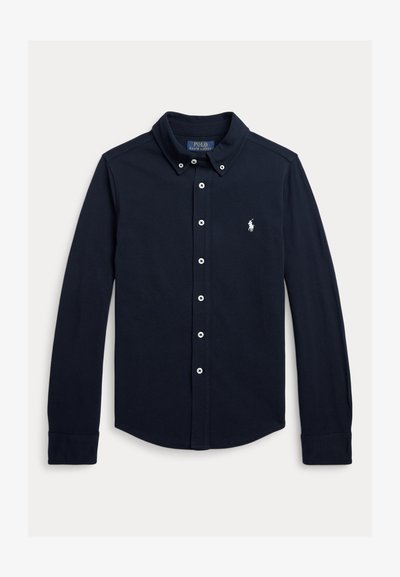 Tamsiai mėlyna ilgomis rankovėmis marškiniai su sagomis, apykakle su sagomis ir mažu baltu Polo Ralph Lauren logotipu kairėje krūtinės pusėje.