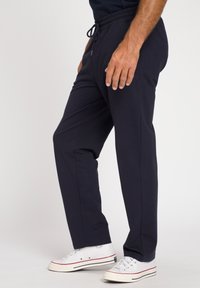 Pantaloni da tuta blu navy realizzati in morbido misto cotone, dotati di cintura elastica con coulisse, tasche laterali e gamba a sigaretta.