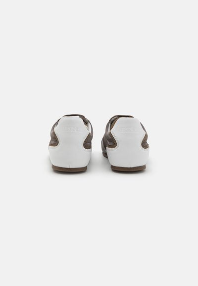 Baskets marron et blanches en cuir, avec un design à profil bas, un talon arrondi et un logo embossé à l'arrière.