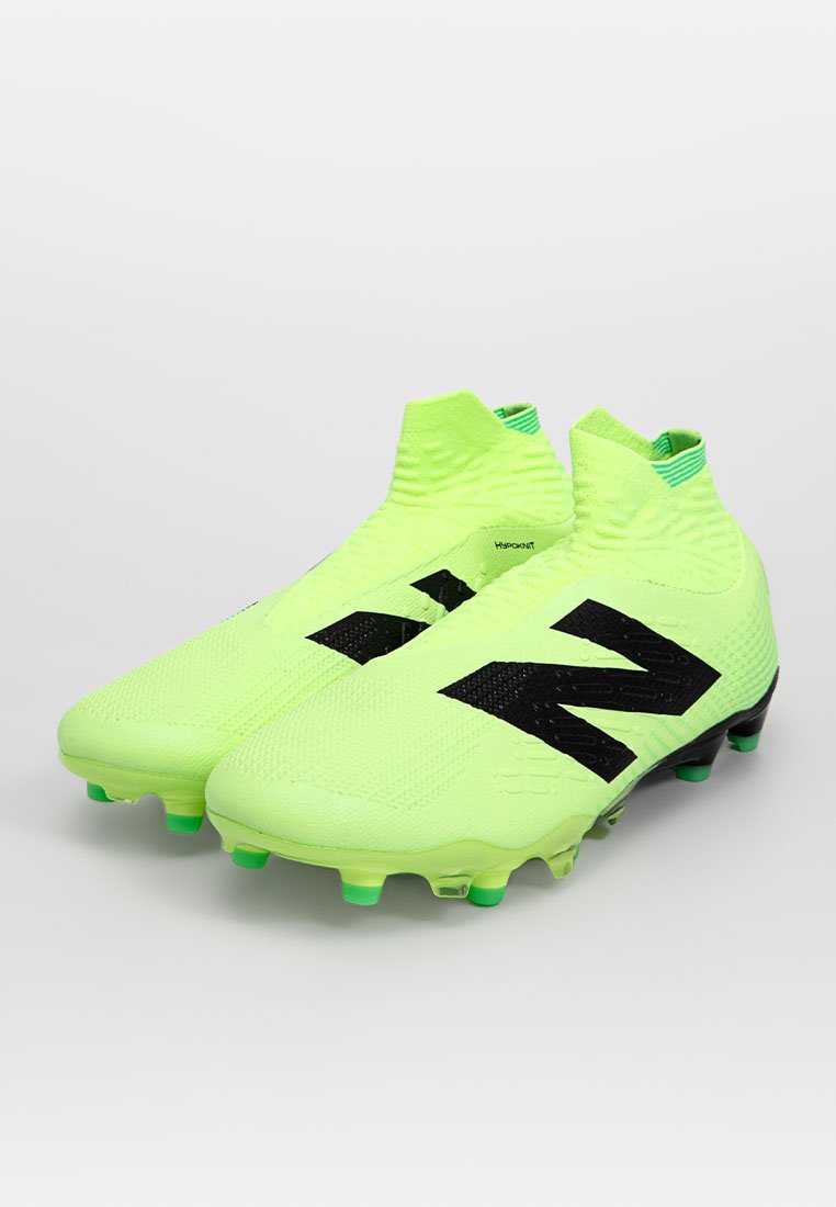 Botas de fútbol verde neón con un logotipo negro, parte superior texturizada y un diseño tipo calcetín. Presenta tacos moldeados para tracción en el césped.