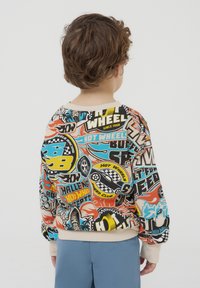 Maglione colorato con vari stampati grafici, prevalentemente in rosso, blu e giallo. Collo e polsini a costine, materiale in cotone.