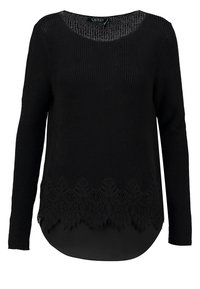 Svart stickad tröja med långa ärmar, rund halsringning och en scalloped spetsdetalj i fållen. Texturerat tyg med ett slätt inre lager.