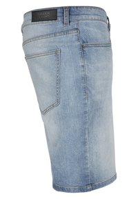 Lys blå denim shorts med lige snit, udstyret med en sort label ved taljen og dobbeltstikning i kanten. To baglommer synlige.