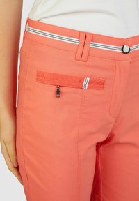 Koraalkleurige broek van een katoenmix, met een ritszak, gestreepte tailleband en een gladde textuur met subtiele stikdetails.