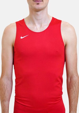 Mężczyzna w czerwonej bezrękawnikowej koszulce sportowej z białym logo Nike, widoczny od ramion do talii na białym tle.