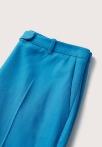 Pantalons tissés bleus avec un devant plat, des plis et une taille ajustée. La texture lisse et les bords nets créent une apparence soignée.