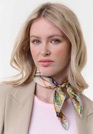 Blonde woman with blue eyes wearing a beige blazer and a colorful floral and animal patterned scarf tied around her neck.