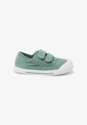 Baskets en toile vert clair avec un bout en caoutchouc blanc et des bandes velcro, posées sur un fond blanc uni.