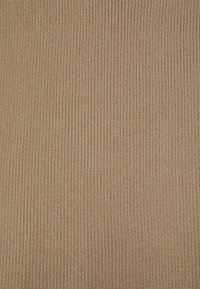 Ribb vävt tyg i en varm, metallisk guldnyans. Har en fin struktur med vertikala linjer och subtil lyster genom hela tyget.