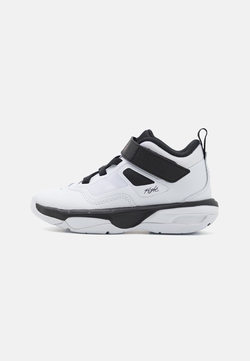 Scarpa sportiva bianca con accenti neri, caratterizzata da un design alto, materiali in rete e sintetici, chiusura con lacci e cinturino regolabile.