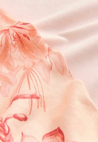 Un material ușor, cu o bază roz deschis, decorat cu modele florale subtile în tonuri de corai și portocalie, care prezintă o textură netedă și un detaliu în plisare.