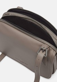 Borsa a tracolla in pelle grigia con più scomparti con zip, superficie testurizzata e tracolla regolabile. Presenta accenti in metallo argentato.