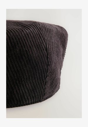 Pouf in cotone a coste di colore grigio scuro con righe verticali, dotato di una parte superiore arrotondata e una base leggermente piatta. Texture morbida con un aspetto accogliente.