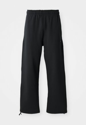 Pantalons larges noirs en tissu doux, dotés d'une taille élastique et d'un cordon de serrage, avec des poches latérales et une texture lisse.