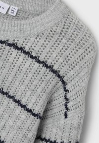 Hellgrau gestrickter Pullover mit einem strukturierten Design aus vertikalen und horizontalen Streifen, akzentuiert durch dunkelblaue Linien.