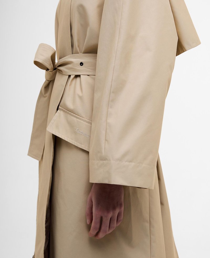 Beige Trenchcoat mit gebundenem Taillengürtel, ausgestattet mit einer Knopfleiste und einer Taschenapplikation. Glatte Textur und lockerer Schnitt mit weiten Ärmeln.