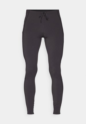 Sorte tights laget av stretchy stoff med snøring i livet, sidelommer og sømdetaljer som går langs utsiden av bena.