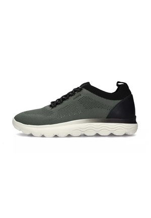 Scarpa sportiva grigia con una tomaia in maglia traspirante, dettagli neri, chiusura con lacci e una suola bianca e imbottita con motivo a onde.