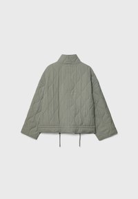 Steppjacke in Hellgrün, mit Mandarin-Kragen, überschnittenen Schultern und verstellbarem Kordelzug-Saum. Strukturiert mit wellenförmigen Mustern.