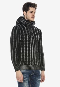 Schwarzer und grauer gestrickter Hoodie mit einem strukturierten Zopfmuster, ausgestattet mit einem hohen Kragen, Toggle-Verschlüssen und gerippten Manschetten und Saum.