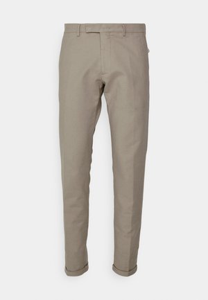 Pantaloni in cotone beige con vestibilità slim, caratterizzati da un fronte piatto, passanti per cintura e orli arrotolati. Texture liscia e linee pulite.