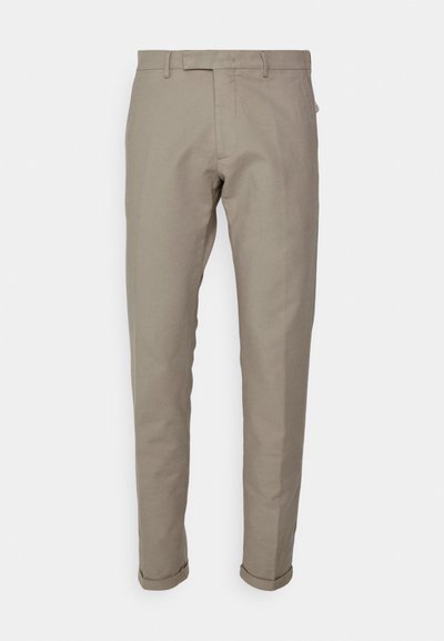 Beige Baumwollhose im Slim-Fit, mit flachem Bund, Gürtelschlaufen und umgeschlagenen Säumen. Glatte Textur und klare Linien.