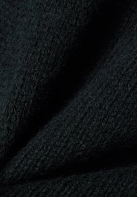 Tissu texturé vert foncé avec un aspect doux et tricoté, présentant un tissage épais et confortable ainsi que de légères variations de brillance.