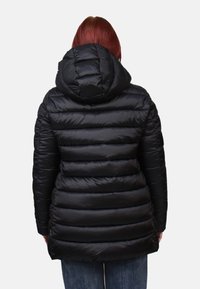 Zwarte pufferjack met horizontale gestikt patroon, verstelbare capuchon en gladde textuur. Draagt met blauwe spijkerbroek, zichtbaar vanuit de achterkant.