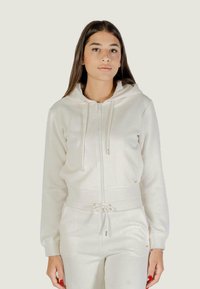 Felpa con cappuccio e zip in tessuto crema con un motivo testurizzato, dotata di lacci, polsini elasticizzati e un orlo aderente.