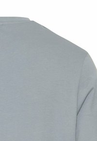 Lysegrå kortærmet skjorte med rund hals, glat tekstur og uden mønstre. Stoffet ser blødt og let ud.