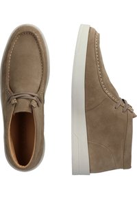 Chaussures en daim marron à bout arrondi, semelle en caoutchouc blanche et détails cousus. Comprend un laçage et une texture lisse.