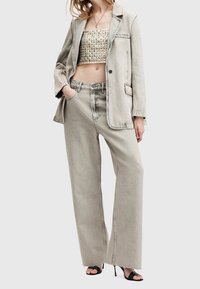 Harmaa farkkutakki yhdistettynä teksturoituun beigeen crop topiin ja leveälahkeisiin farkkuihin, joissa on raaka helmaviimeistely, sekä mustiin korollisiin sandaaleihin.