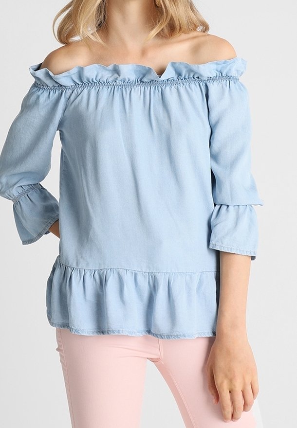 Maglietta azzurra chiara con scollo off-the-shoulder, colletto arricciato e maniche a tre quarti. Presenta una vita arricciata e un orlo svasato.
