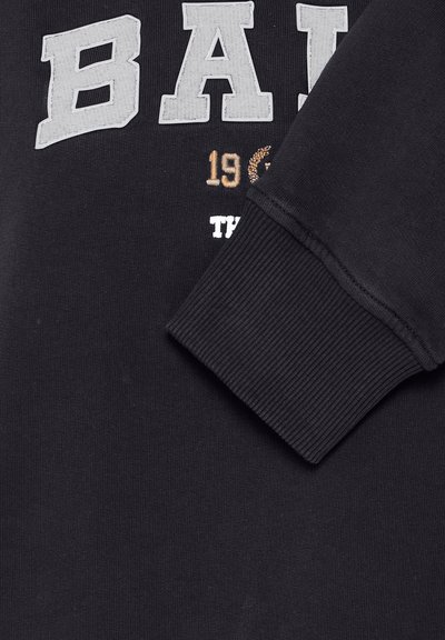 Fekete pulóver nagy szürke blokkbetűkkel "BA" és hímzett részletekkel. Bordás mandzsetták és puha textúra.