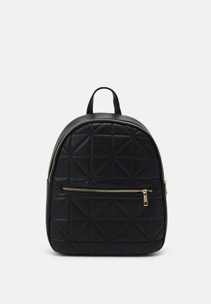 Musta tikattu reppu, jossa kullanvärinen vetoketju etutaskussa ja pääosassa, varustettuna yläkahvalla ja pyöreillä muodoilla.