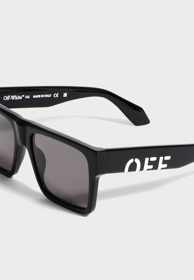 Lunettes de soleil rectangulaires noires avec verres foncés, logo "OFF" en blanc sur la branche et marquage "Off-White" à l'intérieur de la branche.
