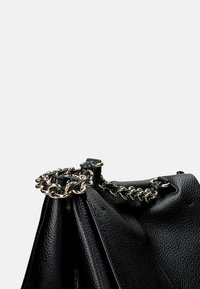 Borsa in pelle nera con una finitura testurizzata, caratterizzata da un accento in catena silver nella parte superiore e un'apertura arricciata.