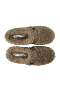 Brune, fuzzy slippers med en blød tekstur, der har en tan rem prydet med metalliske nitter, og en label med teksten "MEDINA BIANCO."