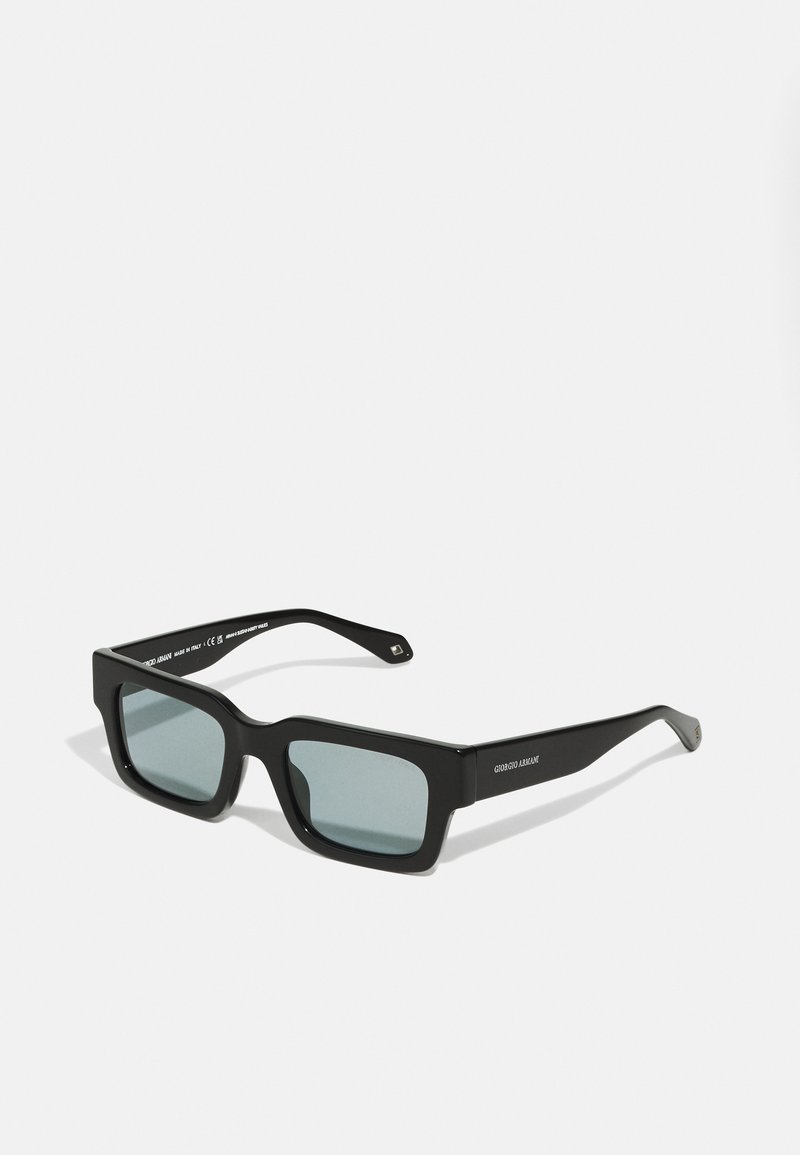 Black rectangular sunglasses with a thick frame and grey tinted lenses. Features a smooth matte finish and subtle logo detail on the arms.