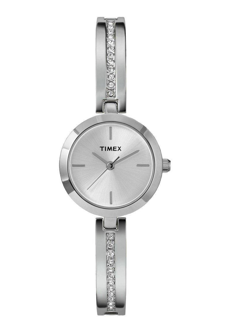 Montre Timex argentée avec un cadran rond, texture métallique brossée, index horaires simples et un bracelet orné d'accents en pierre précieuse transparente.