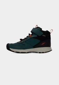 Αθλητικό παπούτσι μεσαίου ύψους σε τιρκουάζ και μαύρο. Διαθέτει υφή επάνω μέρος, ενισχυμένο προστατευτικό δάκτυλων και ρυθμιζόμενο λουράκι. Ανθεκτική λαστιχένια σόλα.