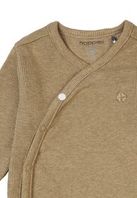 Lysebrun ribstrikket babycardigan med V-hals, trykknapper og præget blomstermotiv. Fremstillet af blødt materiale, egnet til 0-3 måneder.