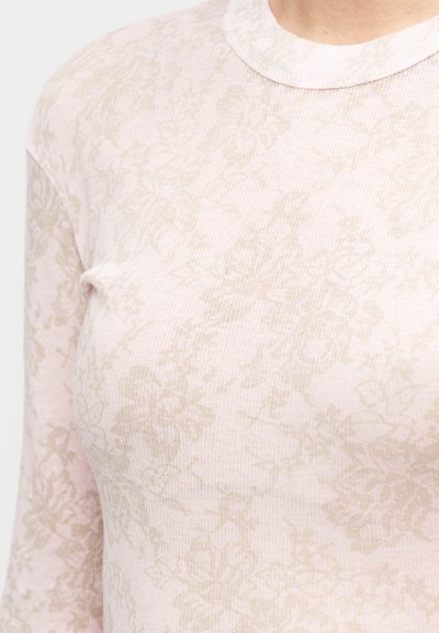 Dolga roza majica z dolgimi rokavi iz teksturirane tkanine, z rahlim bež cvetličnim vzorcem in okroglim vratnim izrezom z rebrastim zaključkom.