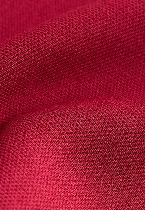 Textilní tkanina v tmavě červené barvě, s tkanou strukturou a malými, rovnoměrnými vzory, vykazující jemné sklady a hladký povrch.