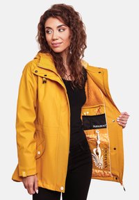 Geel regenjack met capuchon, ritsluiting en zakken. Binnenkant heeft een oranje fleece voering en een mesh zak met een logo.