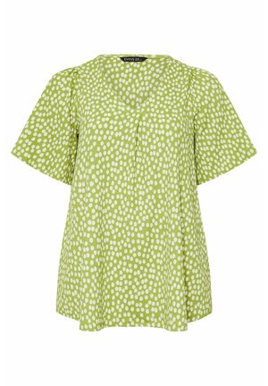 Groene blouse met korte mouwen, losse pasvorm en verspreide witte ovale polka dots, met een V-halslijn en subtiele plooien aan de voorkant.