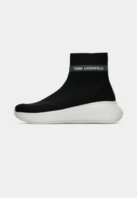 Sapatilha de cano alto tricotada em preto com sola branca ondulada. Apresenta um colar elástico com marca. Design leve com um acabamento texturizado.